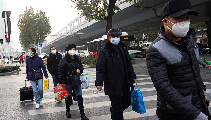 People cross a road amid the coronavirus disease (COVID-19) outbreak, in Wuhan, Hubei province, China December 31, 2022. — Reuters