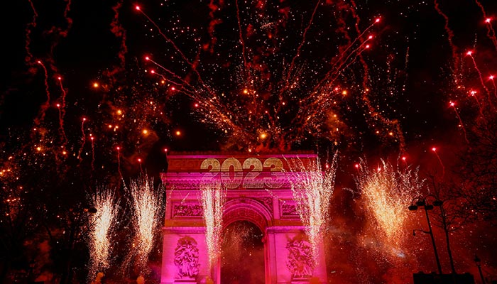 1 جنوری 2023 کو فرانس کے شہر پیرس میں چیمپس ایلیسی ایوینیو پر نئے سال کی تقریبات کے دوران آتش بازی آرک ڈی ٹرومف کے اوپر آسمان کو روشن کرتی ہے۔ — رائٹرز