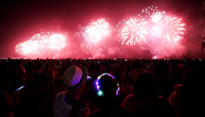 1 جنوری 2023 کو برازیل کے ساؤ پالو ریاست کے سینٹوس میں نئے سال کی شام کی پارٹی کے دوران لوگ آتش بازی کا مظاہرہ دیکھ رہے ہیں۔ — رائٹرز