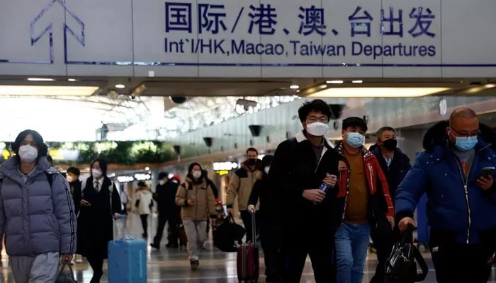 Travellers walk with their luggage at Beijing Capital International Airport, amid the coronavirus disease (COVID-19) outbreak in Beijing, China December 27, 2022. — Reuters