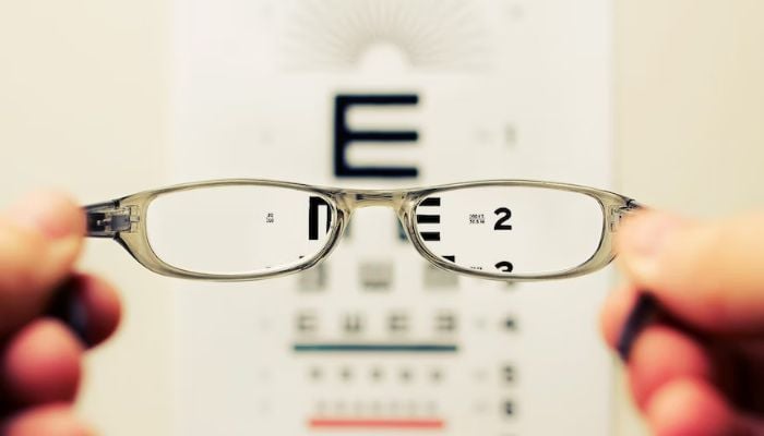 Image shows eye glasses in front of a vision testing board.— Unsplash