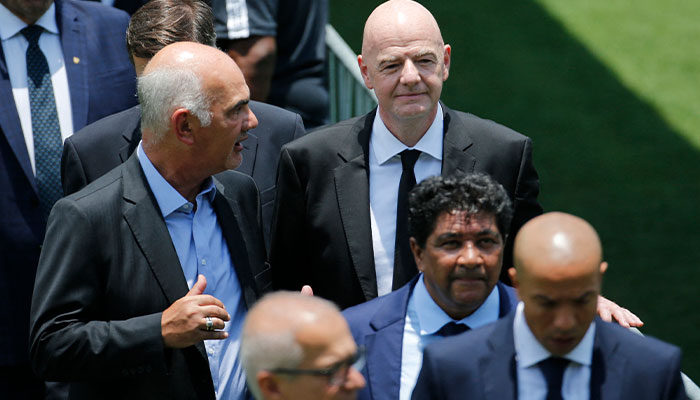 Presiden FIFA Gianni Infantino berfoto dengan pelayat, saat jenazah legenda sepak bola Brasil Pele disemayamkan di lapangan bekas klubnya, stadion Santos Vila Belmiro.  — Reuters