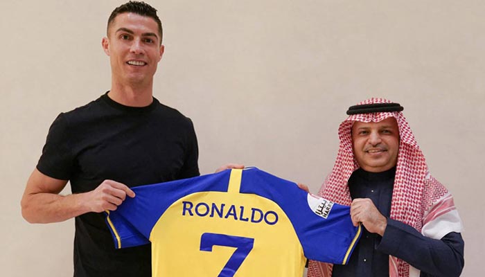 Pemain depan Portugal Cristiano Ronaldo menerima jersey dari Presiden Musalli Al-Muammar dari klub sepak bola Al Nassr.  —AFP
