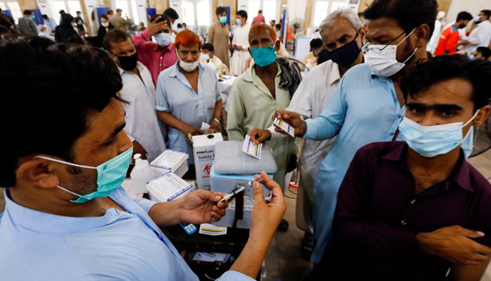 Residents with their registration cards gather at a counter to receive a dose of coronavirus disease (COVID-19) vaccine at a vaccination center in Karachi, Pakistan June 9, 2021. — Reuters