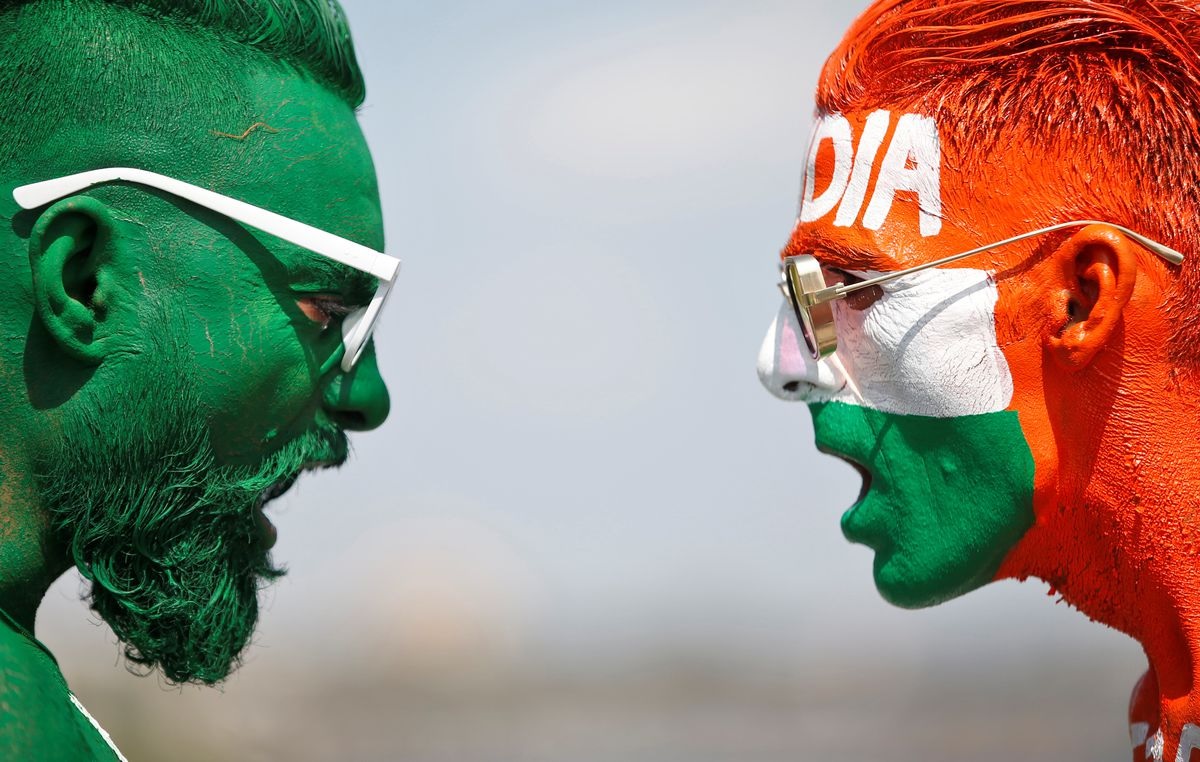 Cricket fans, with their faces painted in the Indian and Pakistani national flag colours, pose for a picture ahead of the first match between India and Pakistan in the Twenty20 World Cup super 12 stage in Dubai. — Reuters/File