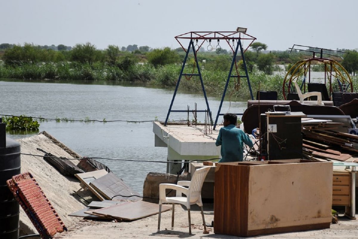 A man sits with his belongings on the roof of his house in a flooded residential area in Hyderabad, September 5, 2022.  — Reuters/File