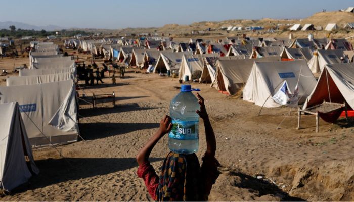 A displaced girl carries a bottle of water she filled from nearby stranded flood-waters, as her family takes refuge in a camp, in Sehwan, Pakistan, September 30, 2022.— Reuters