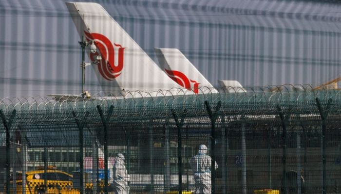 Workers in protective suits stand near planes of Air China airlines at Beijing Capital International Airport as coronavirus disease (COVID-19) outbreaks continue in Beijing, China January 6, 2023.— Reuters