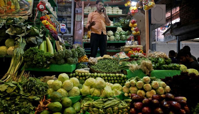 Debashis Dhara, a vegetable vendor, speaks on his mobile phone at a retail market area in Kolkata, India, on March 22, 2022. — Reuters/File