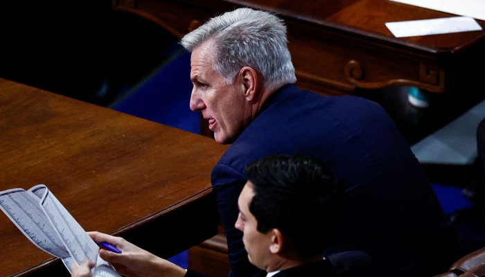 US House Republican Leader Kevin McCarthy is flanked by an aide — Rueters