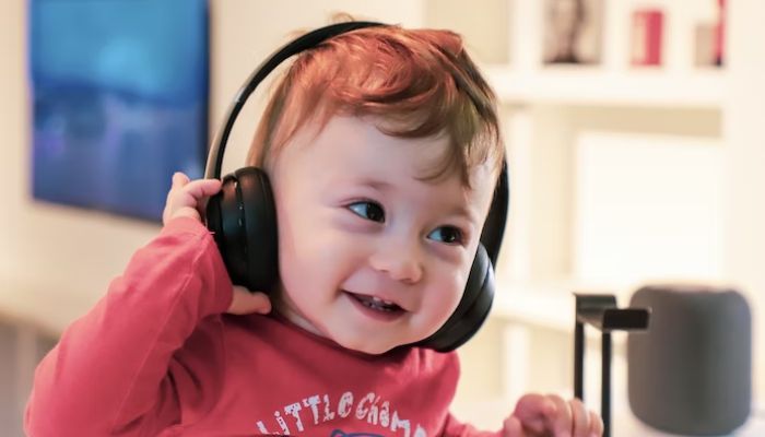 A child smiling while wearing headphones.— Unsplash