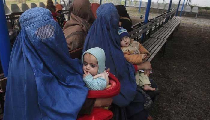 Afghan refugee women sit with their babies as they wait with others to be repatriated to Afghanistan, at the United Nations High Commissioner for Refugees (UNHCR) office on the outskirts of Peshawar, February 2, 2015. — Reuters