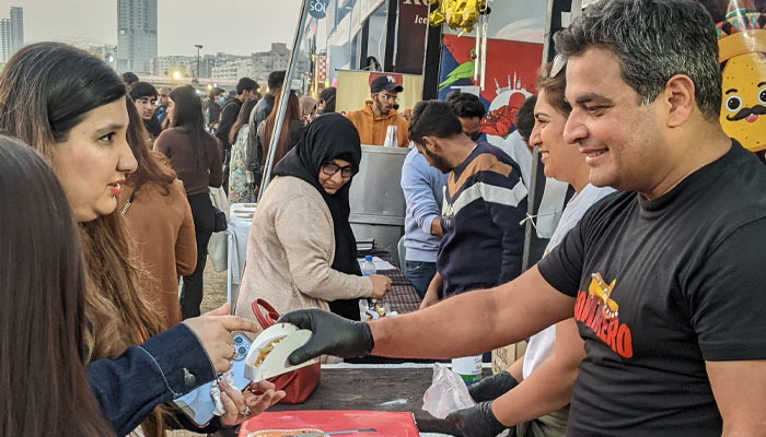 A vendor handing out a taco to a customer at Karachi Eat festival. — reporter