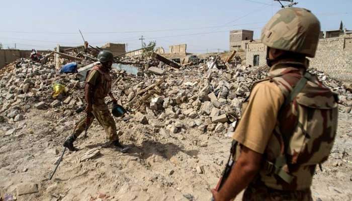 Pakistani soldiers stand near the debris of a house which was destroyed during a military operation against Taliban militants in the town of Miranshah in North Waziristan July 9, 2014. — Reuters