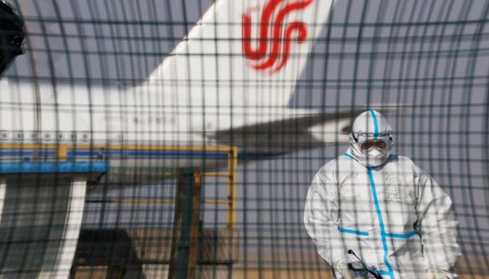 A worker in a protective suit walks near a plane of Air China airlines at Beijing Capital International Airport as coronavirus disease (COVID-19) outbreaks continue in Beijing, China January 6, 2023. — Reuters
