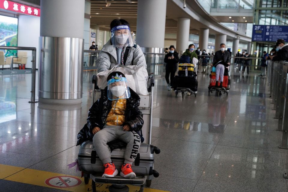 Passengers push their luggage through the international arrivals hall at Beijing Capital International Airport in Beijing, January 8, 2023.— Reuters