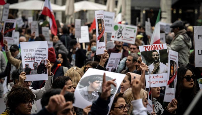 Protestors hold portraits of executed and jailed protestors inside Iran, during a rally in Lyon on January 8, 2023. — AFP