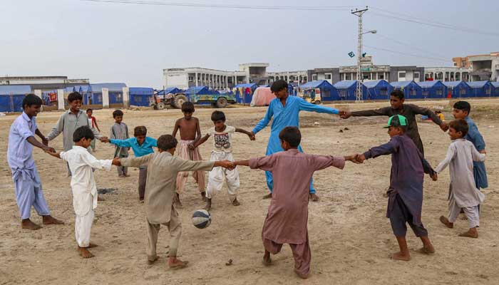 Flood-affected children play along a ground near a makeshift camp in Hyderabad, Sindh province on September 12, 2022. — AFP