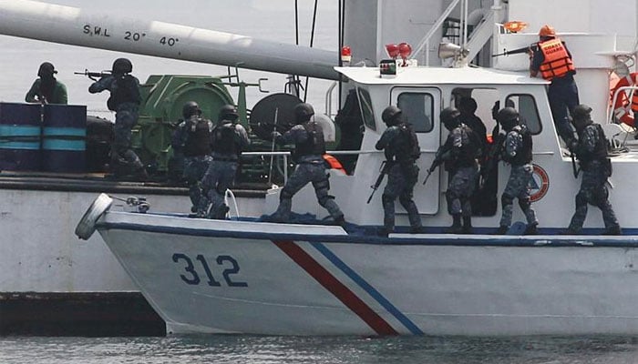 Members of the Philippine Coast Guard (PCG) anti-terrorist unit board a cargo vessel to engage mock pirates who hijacked the vessel during a combined maritime law enforcement exercise at a bay in Manila. — Reuters/File