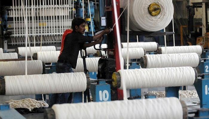 An employee working at a textile factory in Pakistans port city of Karachi, on April 7, 2011. — AFP/FIle