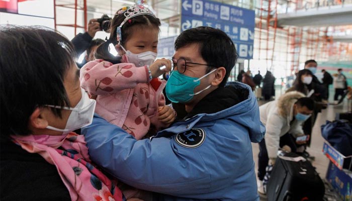 چین نے 8 جنوری 2023 کو بیجنگ، چین میں آنے والے مسافروں کے لیے کورونا وائرس کی بیماری (COVID-19) کے قرنطینہ کی ضرورت کو ختم کرنے کے بعد بیجنگ کیپیٹل انٹرنیشنل ایئرپورٹ پر بین الاقوامی آمد کے دروازے پر لوگ گلے لگا رہے ہیں۔ — رائٹرز