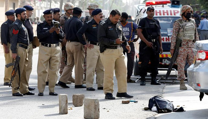 Police officers gather and take pictures of a bag with explosives with their cell phones, after an attack on the Chinese consulate, in Karachi. — Reuters/FileForce being deployed in different areas from training centres.Personnel to be stationed in sensitive locations. Troops to work in three shifts to preventing street crime.