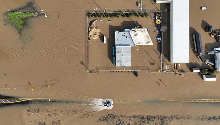 یہ فضائی منظر 10 جنوری 2023 کو مرسڈ، کیلیفورنیا میں سیلاب زدہ سڑک پر گاڑیاں چلاتے ہوئے دکھاتا ہے۔ — اے ایف پی