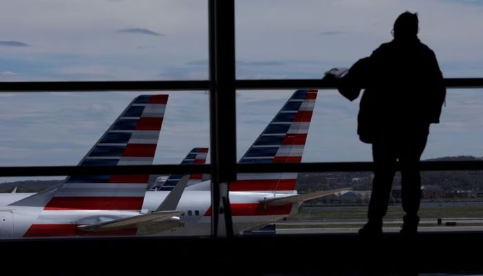 American Airlines aircraft are seen while a passenger waits for boarding at the Reagan International Airport in Washington, U.S., April 3, 2020.— Reuters