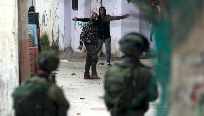 Armed Israeli soldiers clash with unarmed Palestinian protestors in this undated photograph. — AFP/Files
