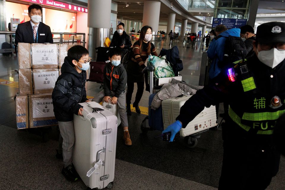 چین نے 8 جنوری 2023 کو بیجنگ، چین میں آنے والے مسافروں کے لیے COVID-19 قرنطینہ کی ضرورت کو ختم کرنے کے بعد مسافر اپنا سامان بیجنگ کیپیٹل انٹرنیشنل ایئرپورٹ پر بین الاقوامی آمد کے ہال کے ذریعے دھکیل رہے ہیں۔— رائٹرز