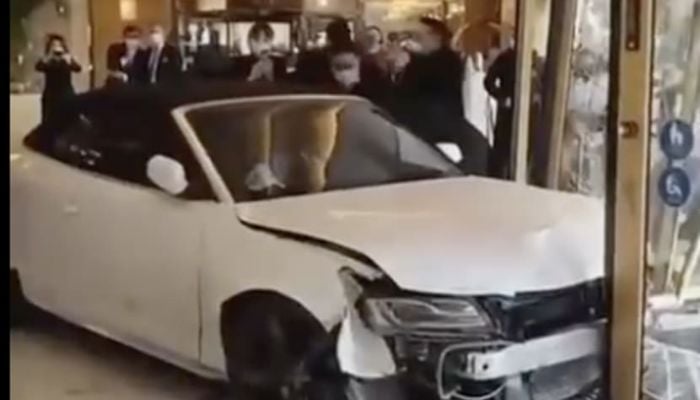 Several videos published on social media showed the white car smashing the glass doors of the central Shanghai hotel from their hinges.— Screengrab via Twitter/Byron Wan