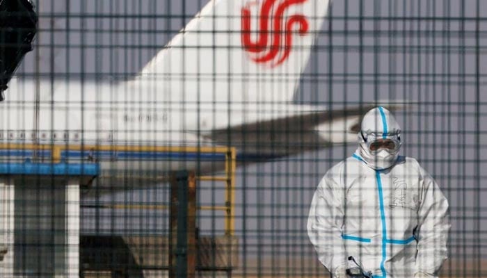 A worker in a protective suit walks near a plane of Air China airlines at Beijing Capital International Airport as coronavirus disease (COVID-19) outbreaks continue in Beijing, China January 6, 2023. — Reuters