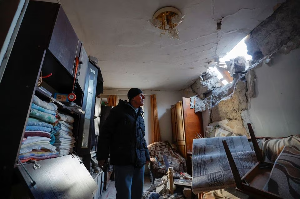 مقامی رہائشی اناتولی اپنے گھر کے اندر کھڑا ہے جو 10 جنوری 2023 کو روس کے زیر کنٹرول یوکرین کے ڈونیٹسک میں روس-یوکرین تنازعہ کے دوران حالیہ گولہ باری سے شدید نقصان پہنچا ہے۔— رائٹرز