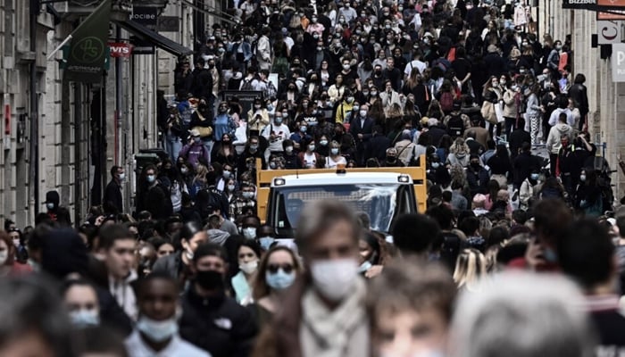 People walk in a crowded shopping street after businesses re-opened after the COVID-19 lockdown in Bordeaux on May 19, 2021. — AFP