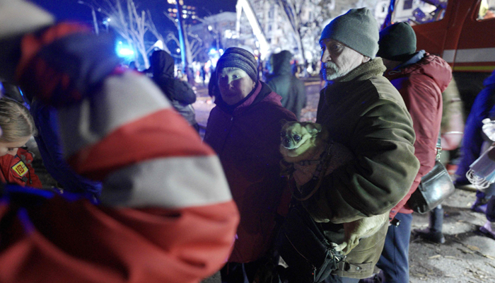 Local residents evacuated from a residential building destroyed after a missile strike, in Dnipro.— AFP