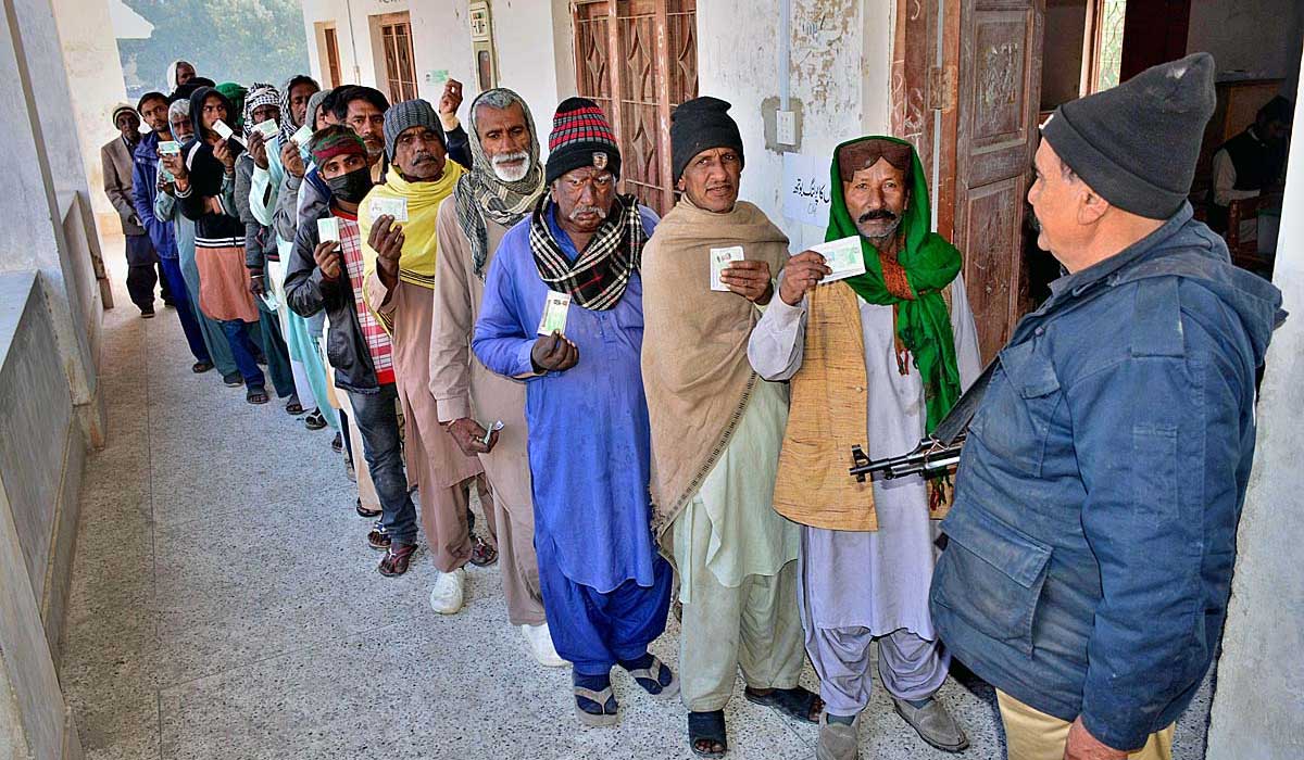 Orang-orang menunjukkan CNIC mereka sambil mengantri di tempat pemungutan suara di Hyderabad.  - APLIKASI