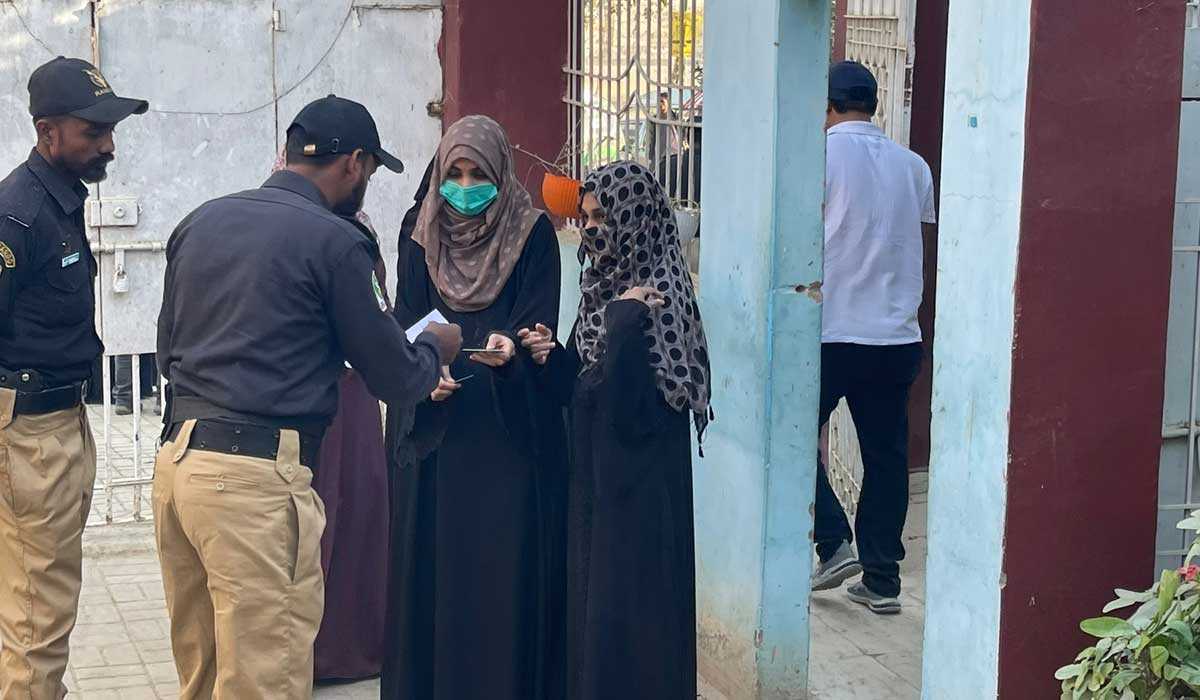 Two burqa-clad women enter a polling station premises to cast their votes during the second phase of local body polls in Karachi on January 15, 2023. — Geo.tv/Rana Jawaid