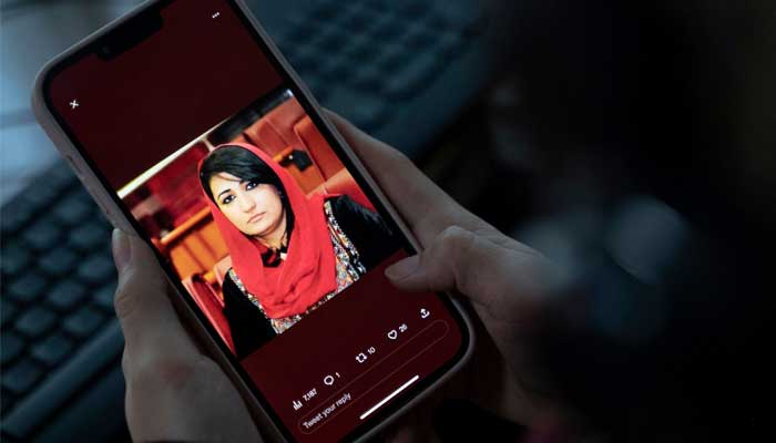 A woman looks at a picture of former Afghan lawmaker Mursal Nabizada on her mobile phone, who was shot dead by gunmen last night at her house in Kabul on January 15, 2023. — AFP