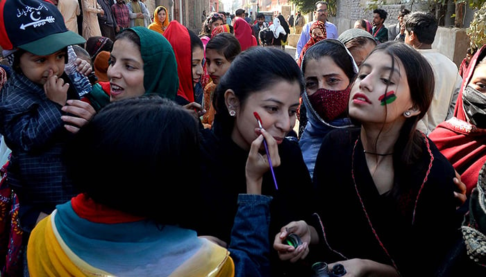 Pakistan Peoples Party supporters painting their party's colours on their faces during the local body election in Hyderabad on January 15, 2023. — INP