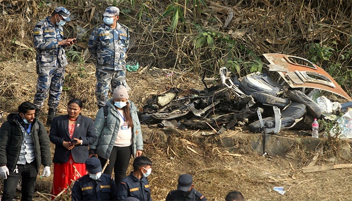 People stand near the wreckage at the crash site of an aircraft carrying 72 people in Pokhara in western Nepal on January 15, 2023. — Reuters