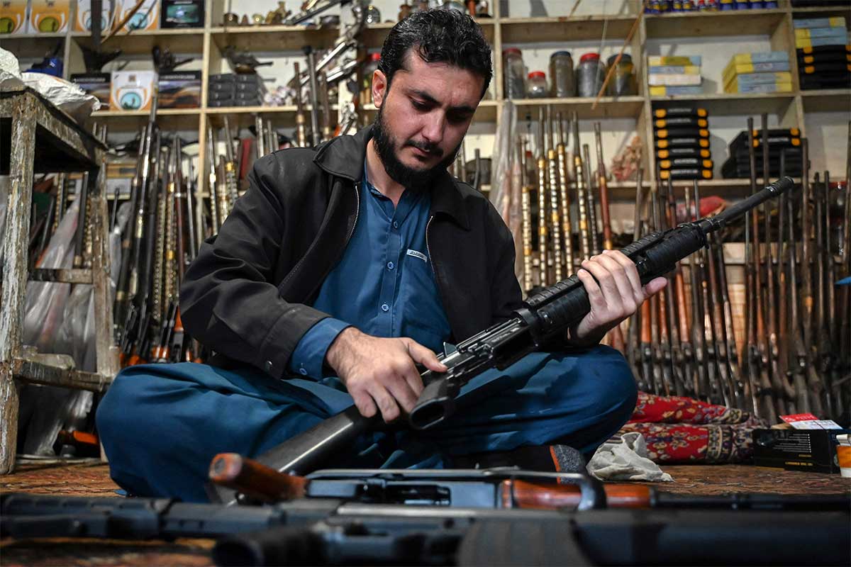 In this photograph taken on January 4, 2023, an arms dealer Muhammad Jahanzeb checks an automatic gun at his shop in Darra Adam Khel town, some 35km south of Peshawar. — AFP