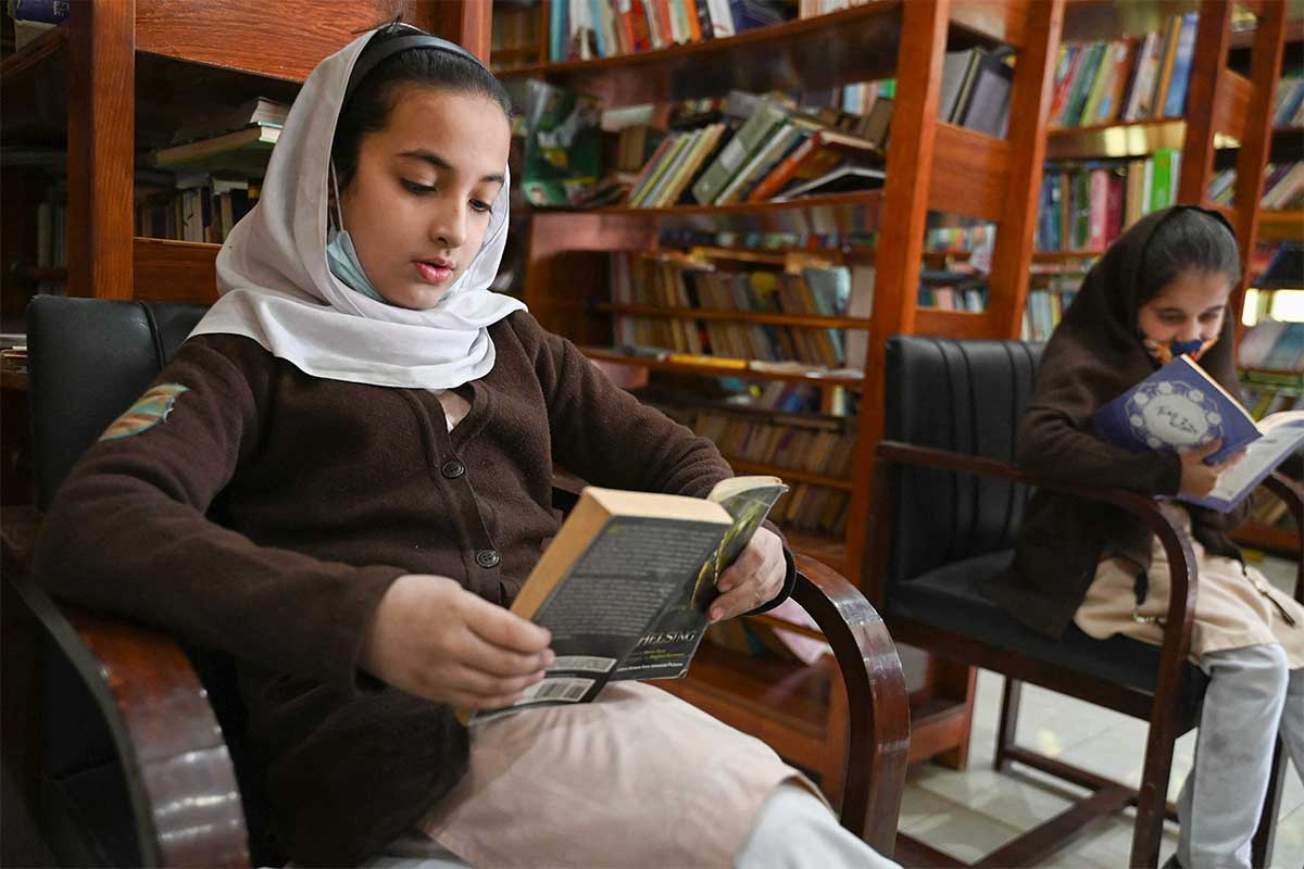 Siswa sekolah membaca buku di dalam Perpustakaan Darra Adam Khel.  —AFP