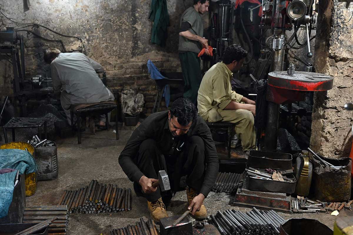 Tukang senjata bekerja di toko senjata di Darra Adam Khel.  —AFP