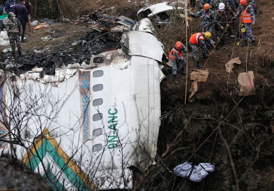 ایک ریسکیو ٹیم 16 جنوری 2023 کو نیپال کے پوکھارا میں Yeti Airlines سے چلنے والے طیارے کے حادثے کی جگہ سے ایک متاثرہ شخص کی لاش برآمد کر رہی ہے۔— رائٹرز