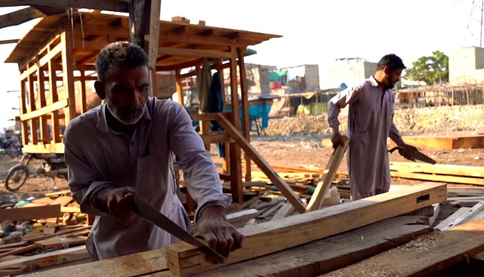 Boatmakers working on seafaring vessels in Karachi. — Facebook screengrab/Geo Digital