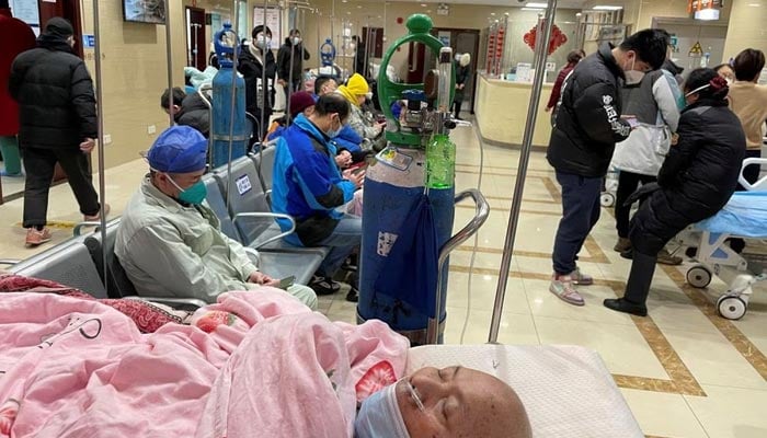 شنگھائی، چین میں 17 جنوری 2023 کو کورونا وائرس کی بیماری (COVID-19) کے پھیلنے کے درمیان ایک مریض ہسپتال کے ایمرجنسی ڈیپارٹمنٹ میں بستر پر لیٹا ہے۔ – رائٹرز