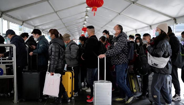 People walk with their luggage at a railway station during the annual Spring Festival travel rush ahead of the Chinese Lunar New Year, as the coronavirus disease (COVID-19) outbreak continues, in Shanghai, China January 16, 2023. — Reuters