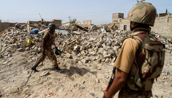 پاکستانی فوجی 9 جولائی 2014 کو شمالی وزیرستان کے قصبے میران شاہ میں طالبان عسکریت پسندوں کے خلاف فوجی آپریشن کے دوران تباہ ہونے والے مکان کے ملبے کے قریب کھڑے ہیں۔ — رائٹرز