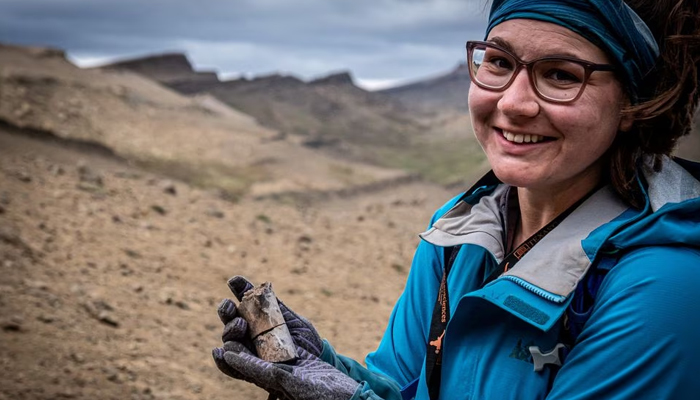A woman holds a fossil at the area where scientists discovered megaraptor fossils at Guido hill in the Chilean Patagonia area. — Reuters