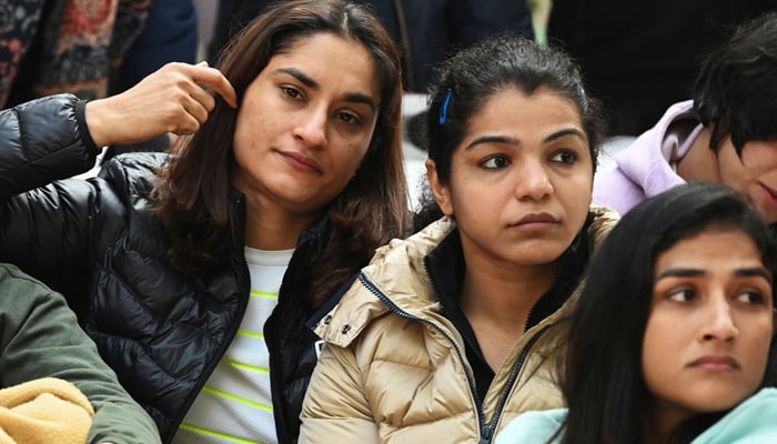 Indian wrestlers Vinesh Phogat (L) and Sakshi Malik (2R) along with others wrestlers take part in an ongoing protest against the Wrestling Federation of India (WFI), in New Delhi on January 19, 2023.— AFP